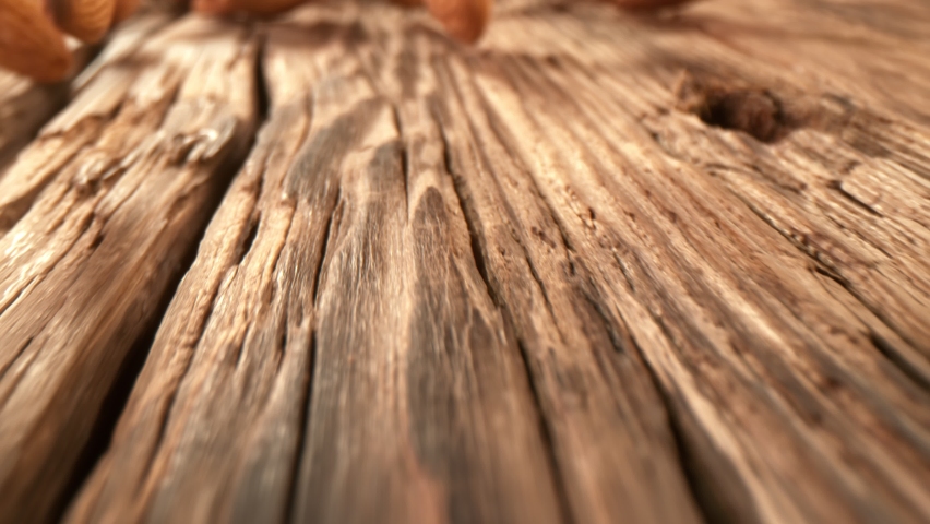 Super Slow Motion Detail Shot of Almonds Rolling Towards on Wooden Background at 1000fps with Camera Motion. Royalty-Free Stock Footage #1068328799