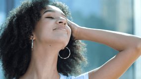 Beautiful confident young African American girl enjoying laughing into camera. Close up portrait happy ethnic female student looking to side upward, curly afro hairstyle, smiling showing healthy teeth - Powered by Shutterstock - Get 15% off with code: PIKWIZARD15