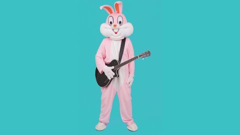 Happy Easter. Funny cute kid boy or girl musician guitarist playing music by guitar, dances having fun, celebrates