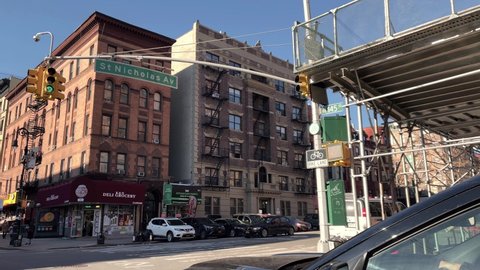 NYC, USA - FEB 25, 2021: driving across 145th street and St Nick in Harlem - Saint Nicholas Avenue - African and Caribbean Market uptown New York City.