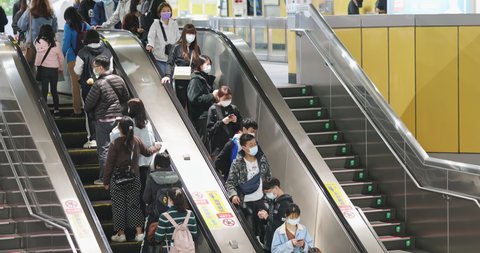 Taipei, Taiwan - February 7, 2021 : crowd of people wearing face mask are using escalator to exit or enter metro mrt station