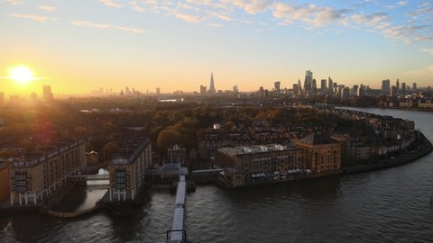 Luxury apartments with River Thames view and beautiful skyline of London in background during golden sunset at horizon. 