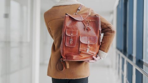 Close-up rear view of a leather backpack hanging on the back