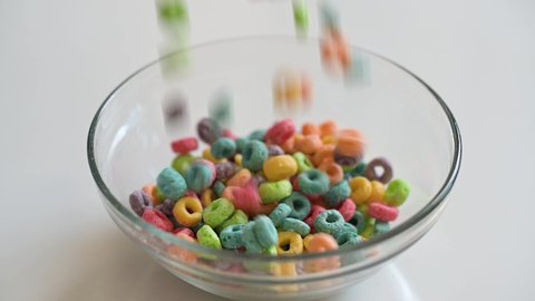 4k slow motion video of a delicious and nutritious fruit cereal loops  falling on a bowl. A healthy breakfast for kids.