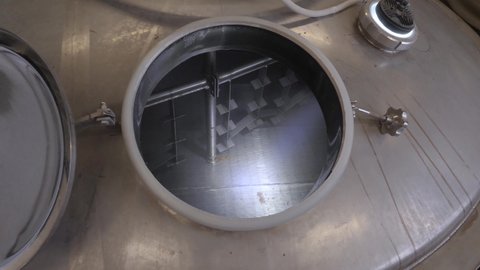 The process of cleaning the malt brew machine with water in a beer production.