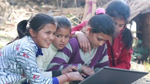 Indian poor girl giving training about laptop computer system at village area open class in India 