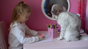 a baby girl draws in her pink room, a cat sits on the table and washes, friends animals and children