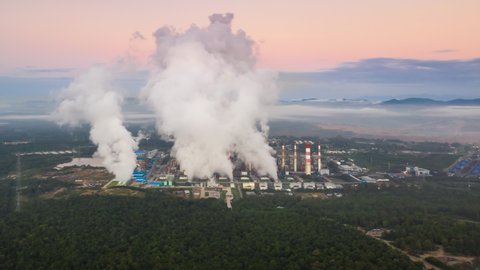 Hyper lapse 4K video, aerial view over coal-fired power plant at sunrise with smoke from cooling, natural power, air environment and industrial concept.