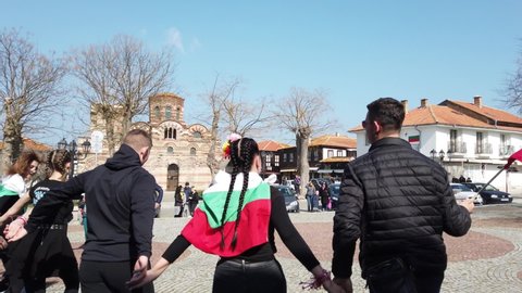 NESEBAR, BULGARIA - MARCH 3, 2021: Celebration on March 3 Liberation Day of Bulgaria in old town Nessebar. Young people dance traditional dance Horo.