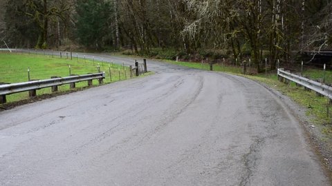 Curve in country road on rainy day 