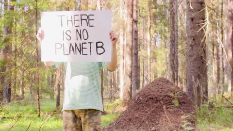 Eco Activist Saving Earth In The Forest With Poster There Is No Planet B, Stands Beside Of Giant Anthill