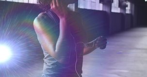 Animation of glowing light over woman putting earphones on before workout in gym. Digital interface global sport and performance concept digitally generated video.