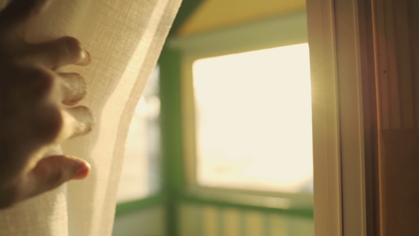 Slow motion hand moves towards a window curtain to reveal the sunlight outside. Sun shines through curtain during afternoon or early morning. Hand reaches slowly and dramatically. Hope and good energy | Shutterstock HD Video #1068430286