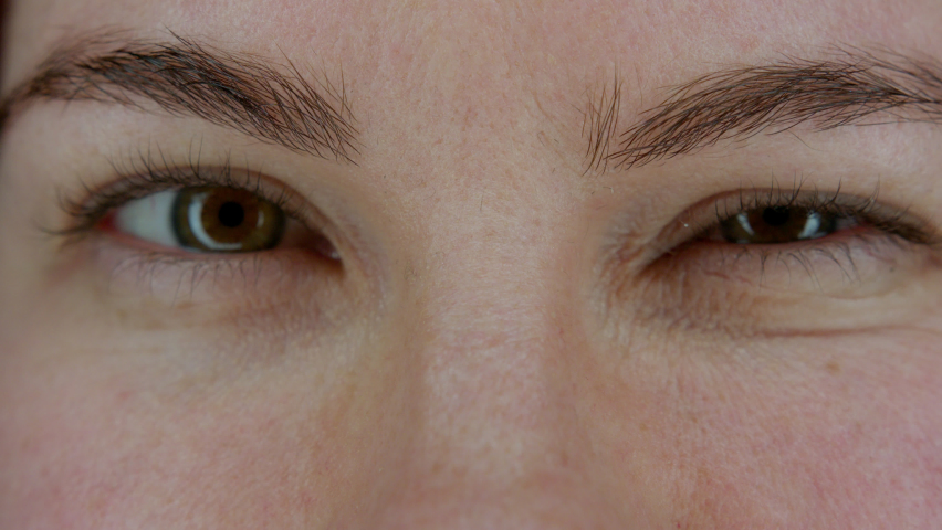 Female eyes looking at camera, winking, blinking with left, right eyes. Close up