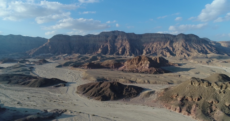 4K panorama drone shot of the Timna Valley in the Arava desert in Israel on a sunny day with a blue sky and a few clouds, aerial view of hills and rocks and cliffs, national park in the Middle East Royalty-Free Stock Footage #1068436223