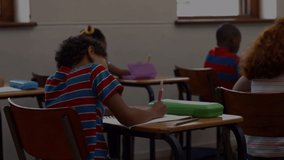 Animation of colourful numbers and letters over a group of kids sitting in classroom writing. education and learning concept digitally generated video.
