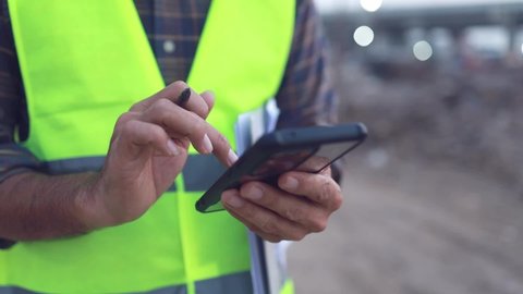 engineer working using smartphone at the construction site