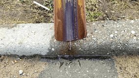 Old and rusty metal drainpipe through which water flows and is blown by the wind. Video full hd on the street in the springtime