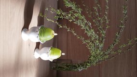 Easter concept. Egg candles and willow on the wooden background. Vertical video