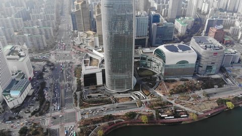 SEOUL, SOUTH KOREA - MARCH 29, 2018: Lotte Shopping Mall and World Tower, aerial shot. Camera fly back and tilt up, reveal panorama and surrounding area of Songpa-gu. Scenic view of Seoul city