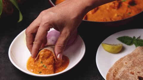 Woman hand eating Paneer butter masala. Paneer tikka masala curry in Delhi Mumbai North Indian vegetarian side dish butter paneer made using cottage cheese, Indian spices 4K video, footage
