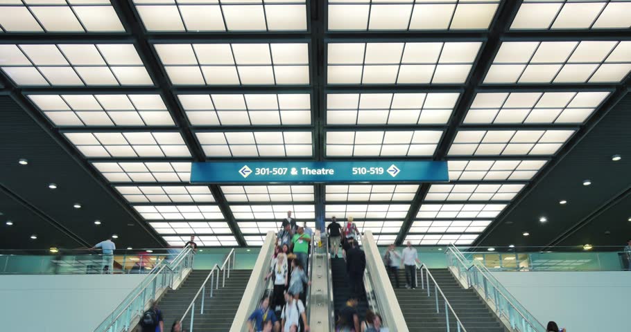 Crowd of people on escalator in a modern interior of to convention expo center. 4K UHD Timelapse.