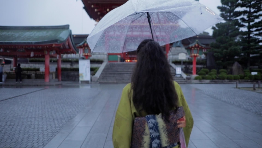Elegant Japanese woman walking in the rain at dawn