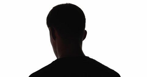 Doubtful man silhouette. Future opportunity. Ambition motivation. Tomorrow perspective. Dark outline of confused guy looking back forward in flicker light isolated on white copy space background.