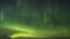 A full screen view of active green and yellow Aurora with a star filled sky in the background.  The Aurora slowly die down towards the end of the video clip. 
