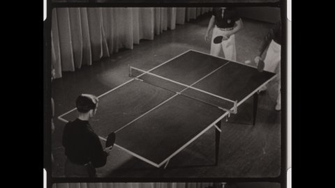 1950s Colorado Springs, CO. Four Men play Table Tennis or Ping Pong in a set of Doubles. Close-up of Ball on Table over Net. 4K Overscan of Vintage Archival 16mm Film Print