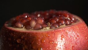 Pomegranate fruit. Slow motion shot. Fresh and ripe Pomegranates rotating over black Background. Organic Bio fruits close-up. Diet, dieting concept. Vegan foo