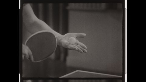 1950s Colorado Springs, CO. Two Men play Tables Tennis or Ping Pong in front of Large Curtain. Close up of Hand, Paddle and Ball. 4K Overscan of Vintage Archival 16mm Film Print