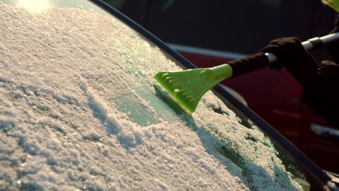 Brushing Snow And Ice From Car Glass.Female Cleaning Fresh Snow After Snowstorm From Vehicle.Sweep Snow From Automobile With Brushes In Winter.Scraping Ice. Scratching Ice From Car Window In Winter.