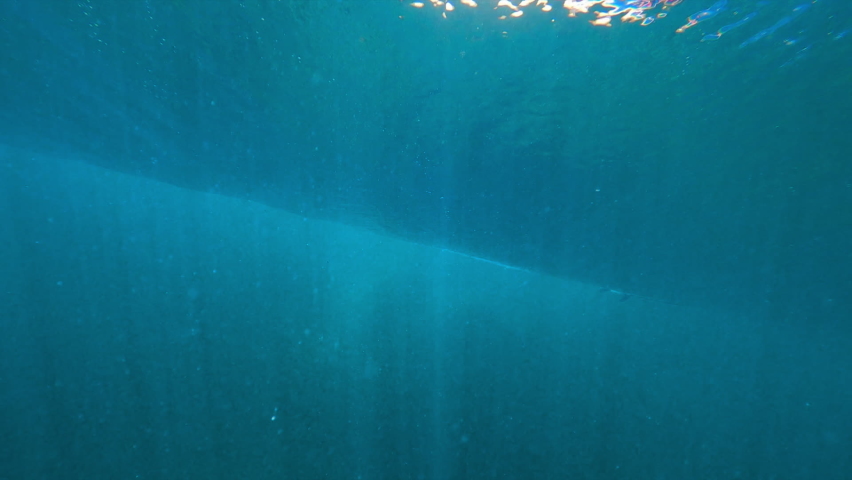 Dramatic underwater of a large ocean wave rolling and breaking, with dark blue water and illuminated bubbles - Oahu, Hawaii | Shutterstock HD Video #1068513647