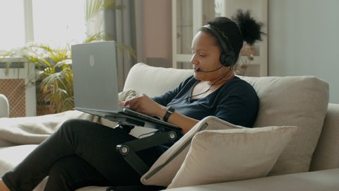MED Portrait of adult Black African American female working from home, having a phone call with client or office. WFH, stay home, COVID-19 coronavirus pandemic new normal concept