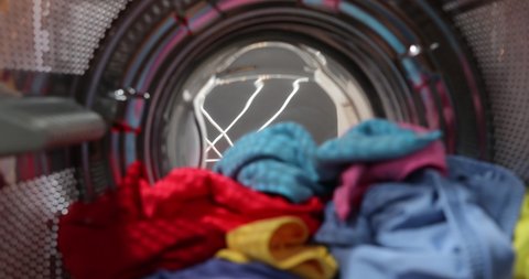 A woman hangs the laundry on the dryer. Housewife Daily Routine. Hanging up washing in a clothes dryer rapid. View Looking Out From Inside Washing Machine