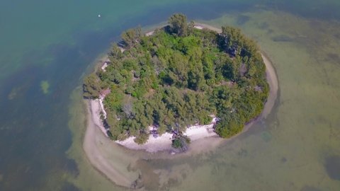 Island in ocean. Small green uninhabited beach or tiny desert island. Blue Gulf of Mexico water. Beautiful wildlife. Wild tropical nature Summer vacations. Aerial view.