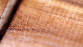 Slow motion Macro video of coffee beans pouring on to a wooden surface