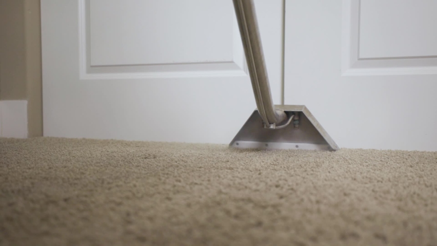 Worker cleaning carpet using professional-grade equipment for steam cleaning hot water extraction of carpet fibers. In bedroom or residential office. Still shot behind wand head, slow stroke 50% speed Royalty-Free Stock Footage #1068522701
