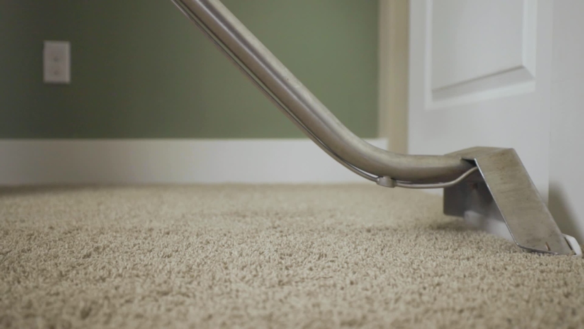 Worker cleaning carpet using professional-grade equipment for steam cleaning hot water extraction of carpet fibers. In bedroom or residential office. Still shot with slow wand stroke, 50% speed. Royalty-Free Stock Footage #1068522704