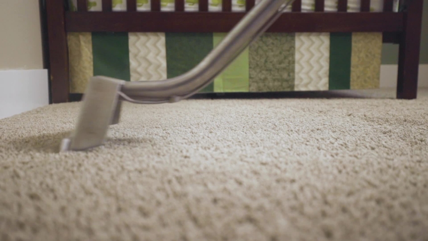Worker cleaning carpet using professional-grade equipment for steam cleaning hot water extraction of carpet fibers. In Baby or Kid's bedroom. Mid shot, pan, wand head, 50% speed. Royalty-Free Stock Footage #1068522707