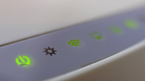 Upgraded: Wi-Fi Router, Home Network, Wireless Technology. A Wi-Fi Internet router with three computers connected to a local network flashes lights in a dark room.