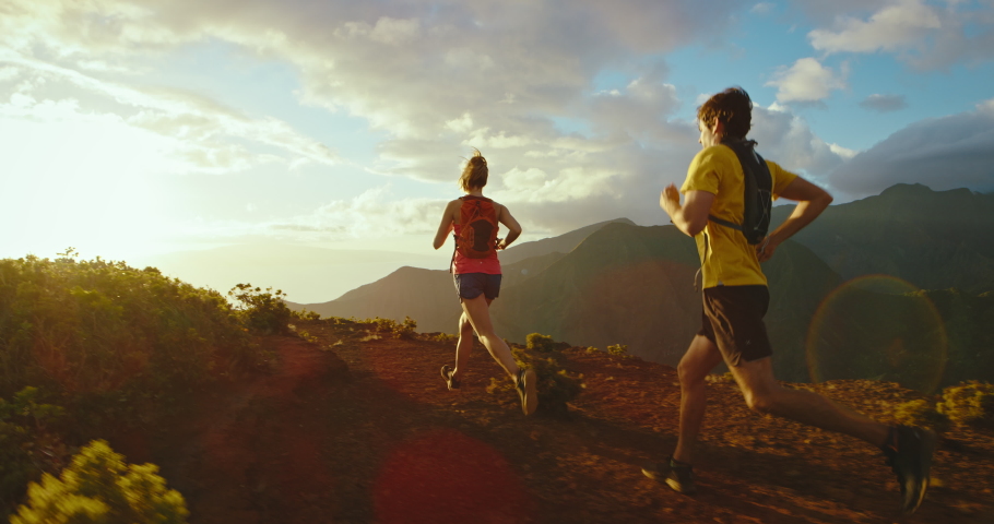 Athletic man and woman running on mountain trail at sunset, healthy fitness lifestyle. Jogging on trail, Shot on RED cinematic slow motion | Shutterstock HD Video #1068525923