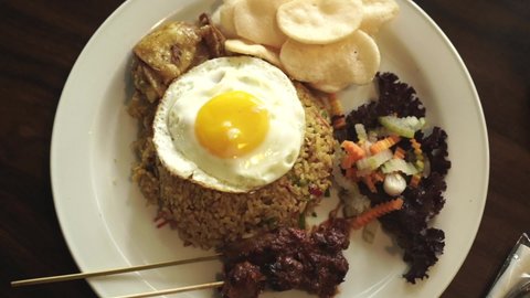 Nasi Goreng or Fried Rice served with egg, and chicken leg, Indonesia Food