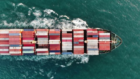 Aerial top view of smart cargo ship carrying container and running for export  goods  from  cargo yard port to other ocean concept freight shipping ship 