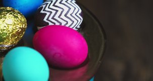 Close up video of colourful festive Easter eggs on plate rotating. Christian religious holiday celebration