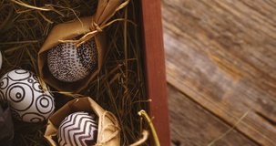 Celebrating Easter, decorated eggs on hay. Close up video of rotating wooden box for christian religious holiday.