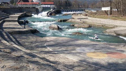 TACEN, SLOVENIA. 2.3.2020. Athletes carrying canoe up the river and training on canoe slalom white water river course with river gates