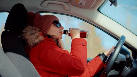 Drunk Driving Sitting On Car.Tired Woman Illegal Vehicle Driving. Drunken Drive Risk Car Accident.Holding Alcohol Bottle In Car. Dangerous On Road Drunk Driving. Stress Unlawful Intoxicated Drive Auto