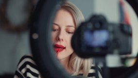 Blonde blogger recording a vlog about cosmetics at home during a pandemic 